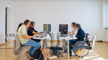 Menschen sitzen vor ihren Laptops