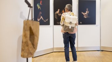 Person steht vor Ausstellungsbildern