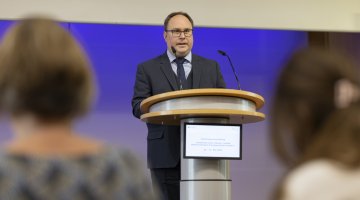 Mensch steht am Rednerpult