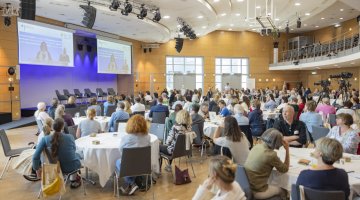 Saal mit Menschen und Tischen