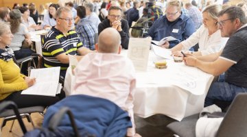 Menschen arbeiten gemeinsam an Tischen