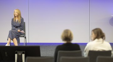 Frau sitzt auf Stuhl auf Bühne